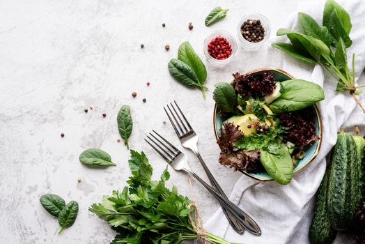 Healthy veggie salad with spinach, red lettuce, cucumbers and greenery top view flat lay with copy space