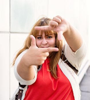 Body positive. Young woman taking picture with imaginary camera