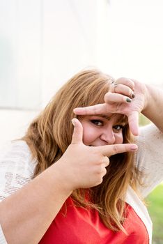 Body positive. Young woman taking picture with imaginary camera