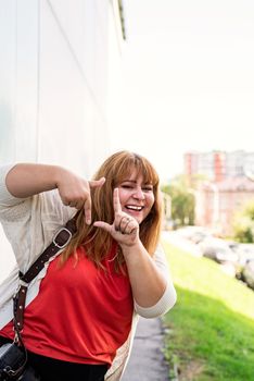 Body positive. Young woman taking picture with imaginary camera