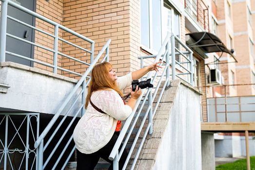 Travel, tourism and entertainment. Plus size woman photographer working at the street