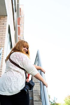 Travel, tourism and entertainment. Plus size woman photographer working at the street