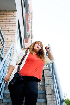 Travel, tourism and entertainment. Plus size woman photographer working at the street