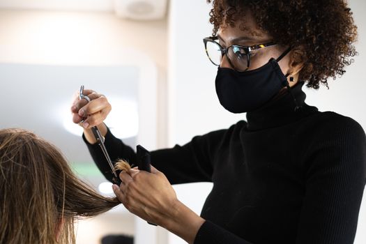 beautiful young hairdresser cutting hair to handsome man in beauty salon