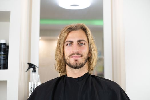 Portrait of young handsome and blonde man after haircut