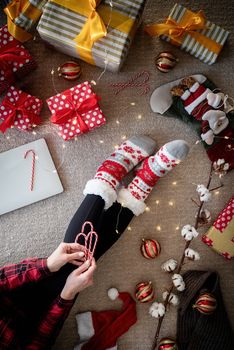 Christmas and New Year. Top view of woman in funny socks celebrating Christmas at home