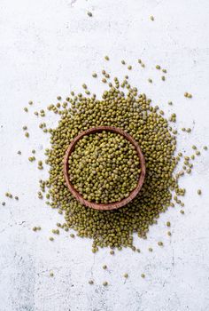 Mung beans top view on gray background, minimal style. Wooden bowl with green mung beans top view flat lay