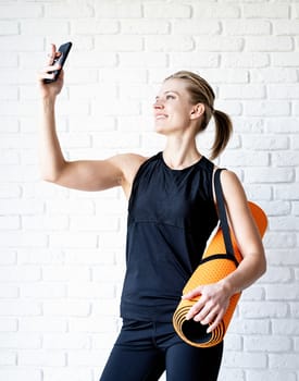 Healthy lifestyle. Sport and fitness. Young smiling fitness woman doing selfie after workout