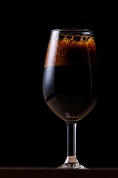 Dark beer in a glass on a dark background