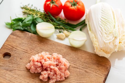 Cooking chicken tenders at home. Chicken fillet sliced into small pieces for the mince on the wooden board