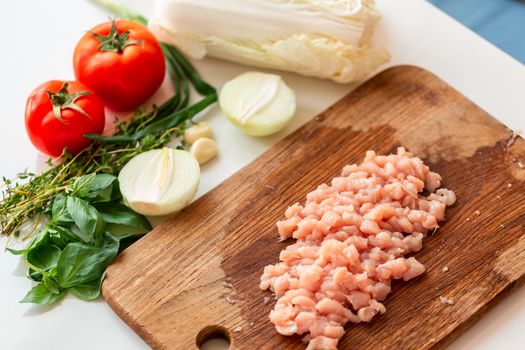 Cooking chicken tenders at home. Chicken fillet sliced into small pieces for the mince on the wooden board