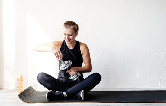 Healthy lifestyle. Sport and fitness. Young blond woman working out with dumbbells