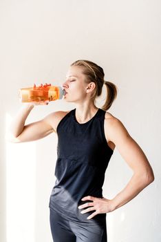 Healthy lifestyle. Sport and fitness. Young blond woman drinking water after workout