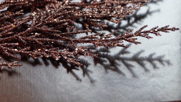 brown gilded branch on a brown background for Christmas blank.