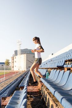 Active lifestyle. Teenager girl working out at the staduim running down the stairs