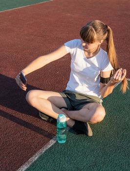 Teenager girl making selfie at the stadium after workout