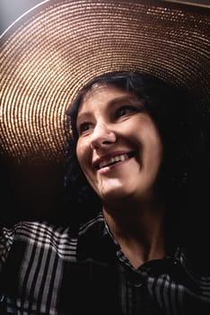 Light and shadow portrait. Portrait of a beautiful young woman in a straw hat with a creative shadow pattern on the face