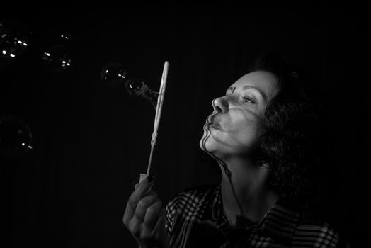 Light and shadow portrait. Black and white. Beautiful young woman with a shadow pattern of soap bubbles on her face