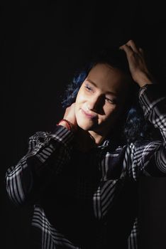 Light and shadow portrait. Beautiful young woman with a shadow pattern on the face on black background