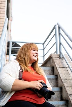 Travel, tourism and entertainment. Plus size woman photographer working at the street