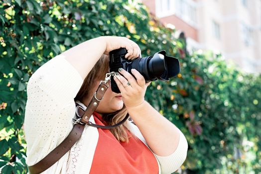 Travel, tourism and entertainment. Plus size woman photographer working at the street