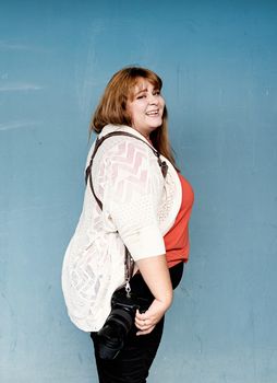 Travel, tourism and entertainment. Plus size woman photographer outdoors on blue solid background