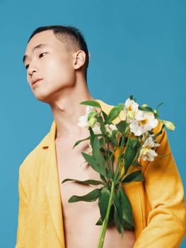 romantic asian man on blue background with bouquet of white flowers cropped view close-up romance. High quality photo