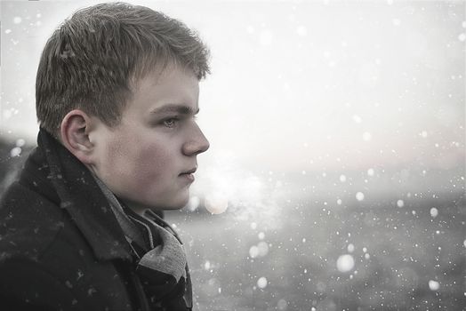 Portrait of handsome young Caucasian man looking away in a winter background. Concept about lifestyle, people, nature and travel.