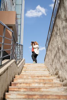 Travel, tourism and entertainment. Plus size woman photographer working at the street