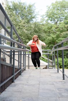 Portrait of a young beautiful caucasian woman dancing on the street having fun