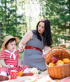 Parks and recreation. Interracial family. Interracial family of mother and daughter in the park having a picnic. Selective focus