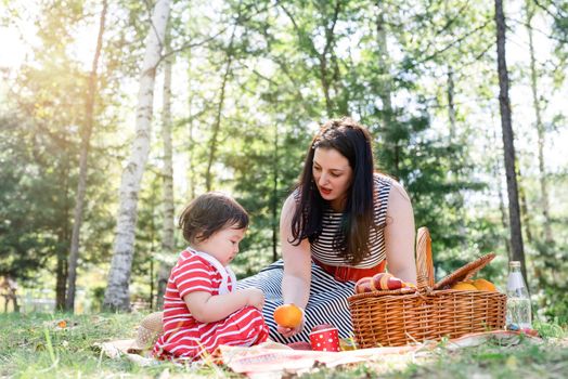 Parks and recreation. Interracial family. Interracial family of mother and daughter in the park having a picnic. Selective focus