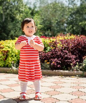 cute asian infant girl dancing in the park