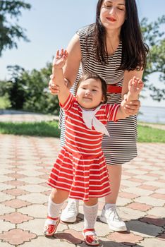 Multiethnic family. Happy multiracial family of mother and daughter walking in the park