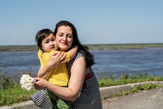 Multiethnic family. Happy mixed race family mother and daughter walking in the park