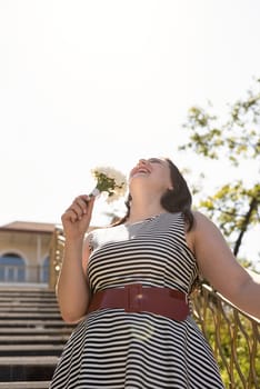 Happy laughing young woman holding a bouquet of flowers