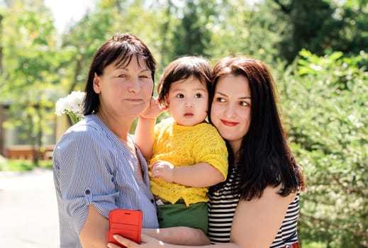 Multiethnic family. A multi generation portrait of a happy grandmother with her daughter and granddaughter