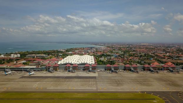 Denpasar International Airport Ngurah Rai, Bali Island, Indonesia. Aircrafts of national Indonesian air carrier in front of airport passenger terminal.