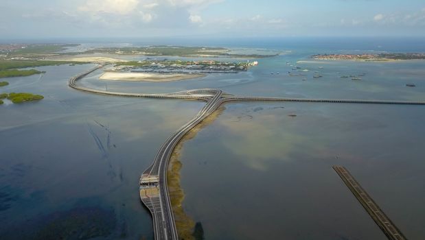 Aerial view of Bali Mandara toll road over sea. Car, motorbike bridge across the Gulf of Benoa connecting Denpasar city and South Kuta, Nusa Dua and Ngurah Rai International Airport.