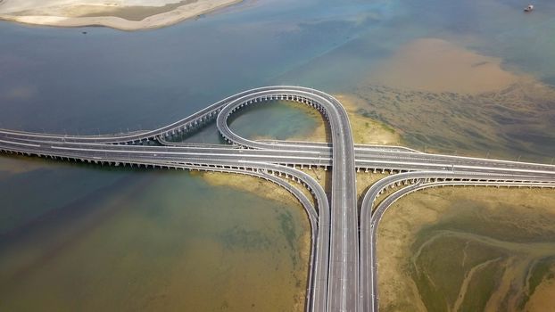 Aerial view of Bali Mandara toll road over sea on Bali island. Car, motorbike bridge across the Gulf of Benoa connecting Denpasar city and South Kuta, Nusa Dua and Ngurah Rai International Airport.