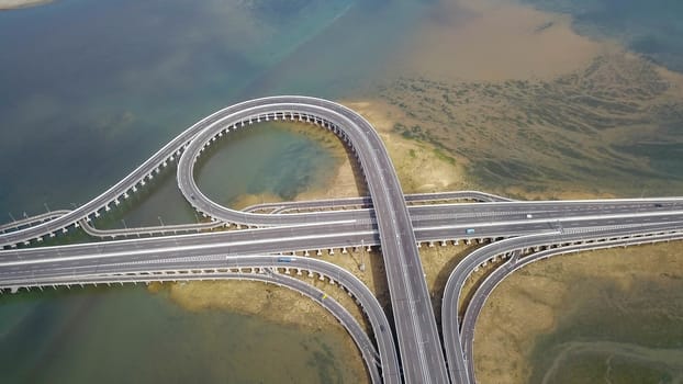 Aerial view to ring road toll way structure and construction from aerial view, nature and urban landscape of Bali before landing at the airport.