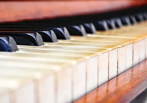 Close up of the keys of an old worn piano. Music and musical instruments