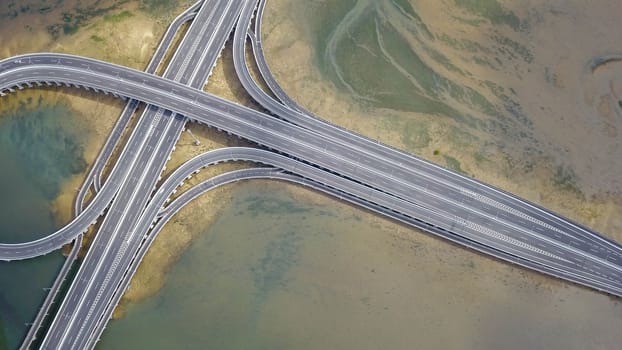 Aerial view to ring road toll way structure and construction from aerial view, nature and urban landscape of Bali before landing at the airport.