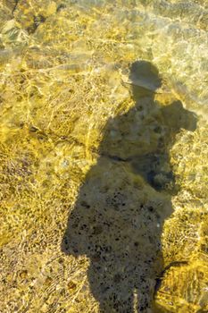 human shadow on the sea shore and in the water