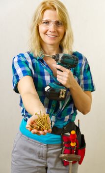 Home work, handywoman concept. Female hands holding a handful of screws Hands show the golden screws