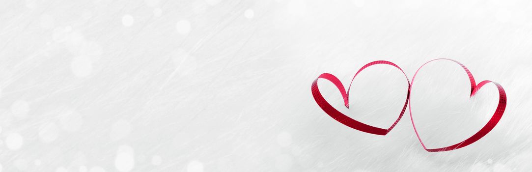 Red heart shaped ribbon on white fur background Valentines day design with copy space