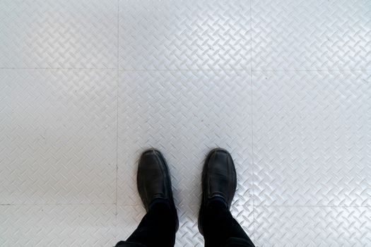 man's feet standing on metal sheet