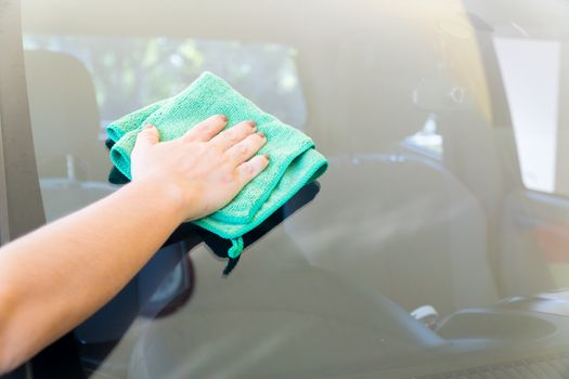 Women are wiping the car glass with microfiber textile