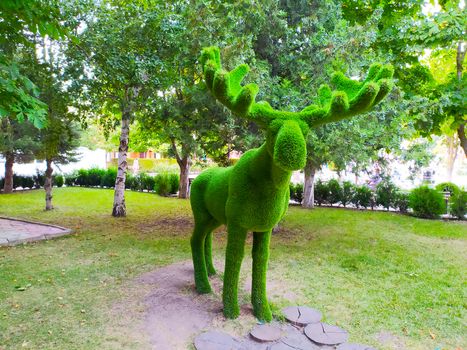 Figure of a deer with green faux fur horns in the Park.