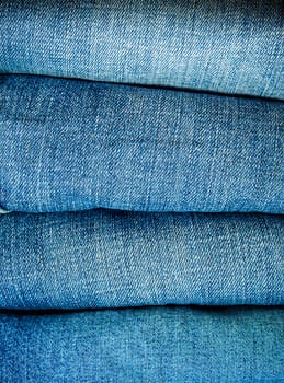 Pile of different blue jeans, fabric texture
